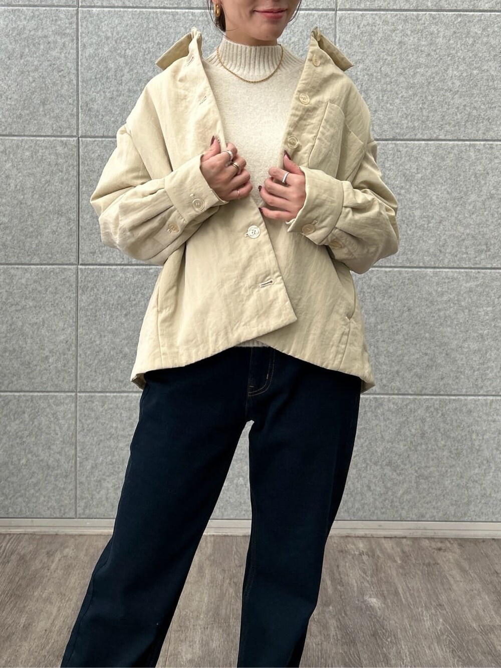 ベージュ系のブルゾン、ホワイト系のニット/セーター、ブルー系のデニムパンツを着用したレディースの冬コーディネートの8枚目の写真