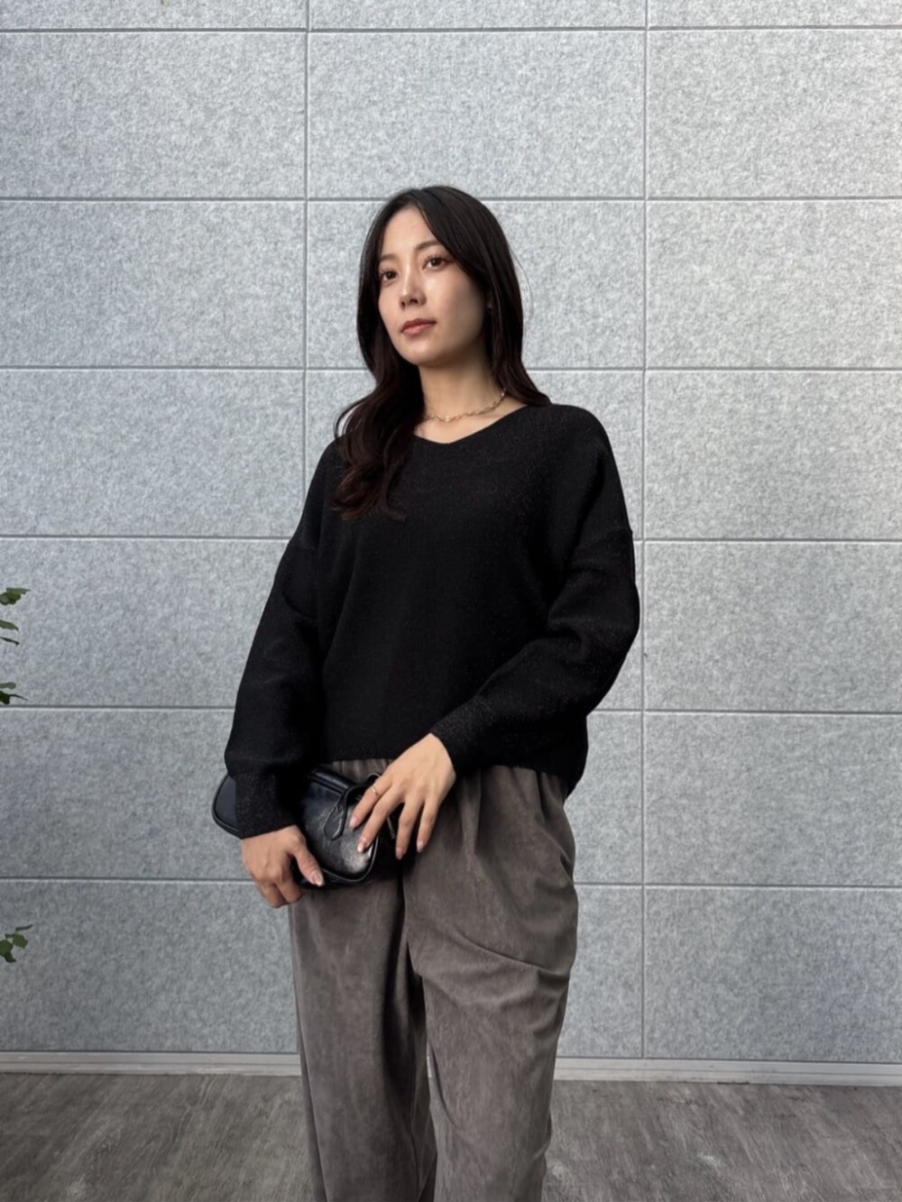 グレー系のその他パンツ、ブラック系のニット/セーターを着用したレディースの秋コーディネートの6枚目の写真