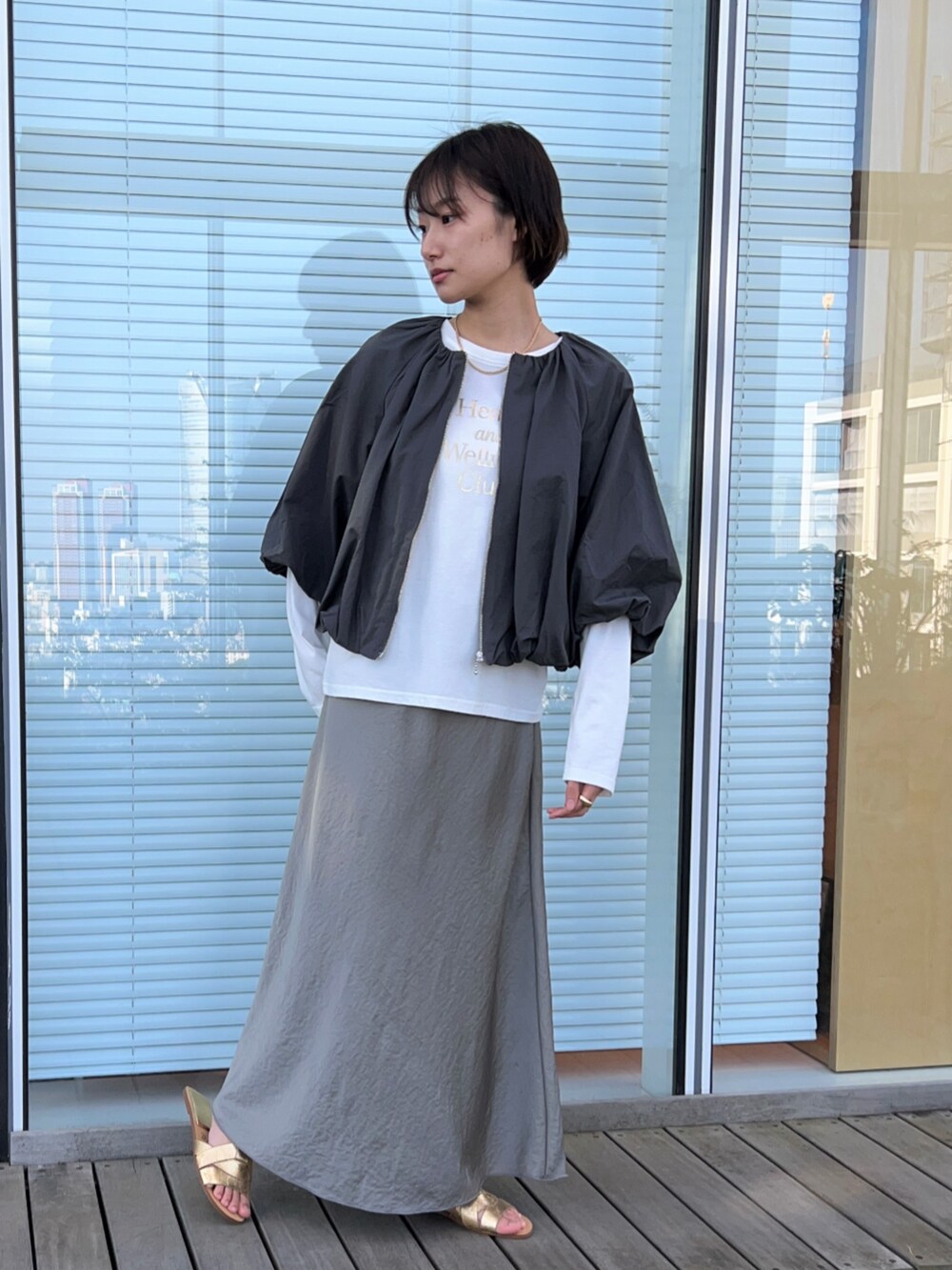 ホワイト系のTシャツ/カットソー、グレー系のブルゾン、グリーン系のスカートを着用したレディースの春コーディネートの2枚目の写真