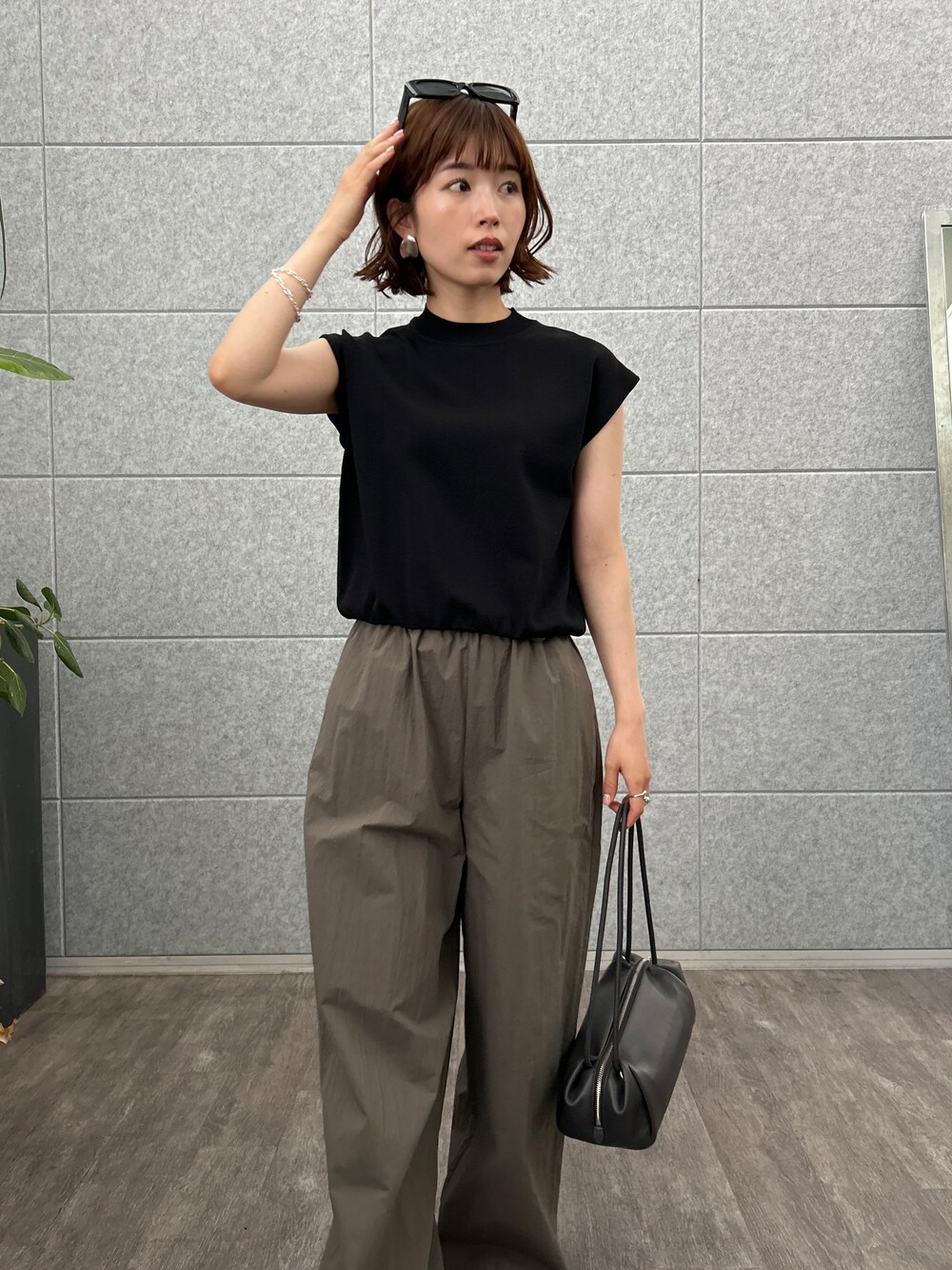 ブラック系のニット/セーター、グリーン系のその他パンツを着用したレディースの夏コーディネートの7枚目の写真