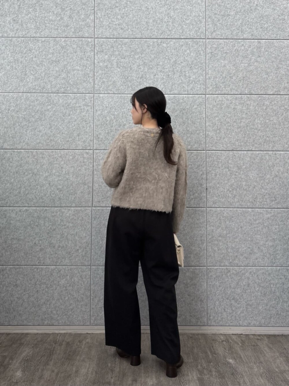 ブラック系のその他パンツ、ホワイト系のニット/セーター、ベージュ系のカーディガン/ボレロを着用したレディースの秋コーディネートの2枚目の写真