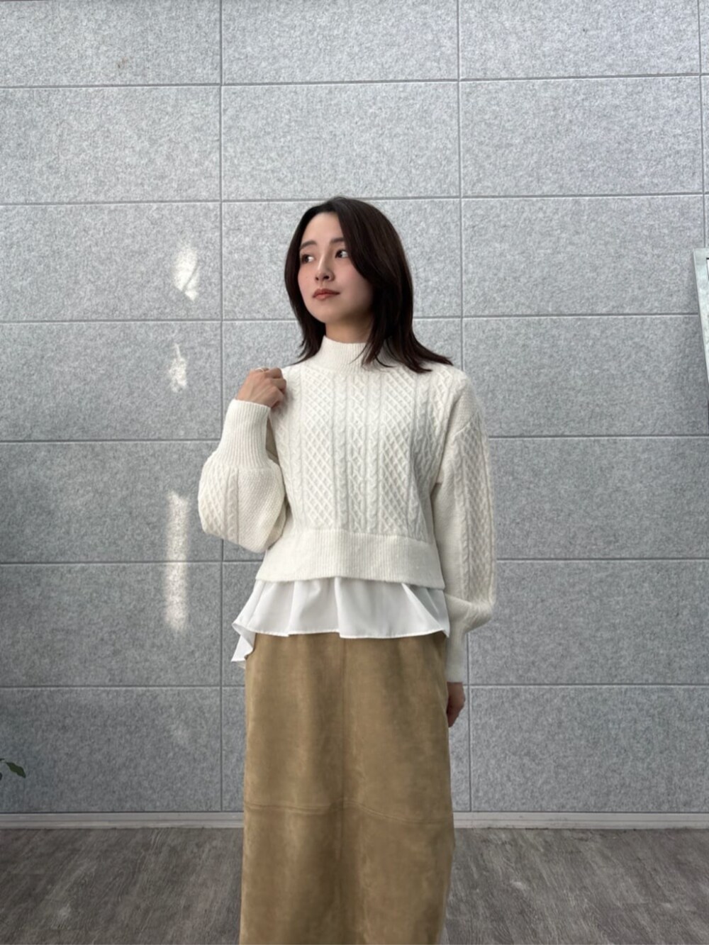 ホワイト系のニット/セーター、ブラウン系のスカートを着用したレディースの冬コーディネートの4枚目の写真