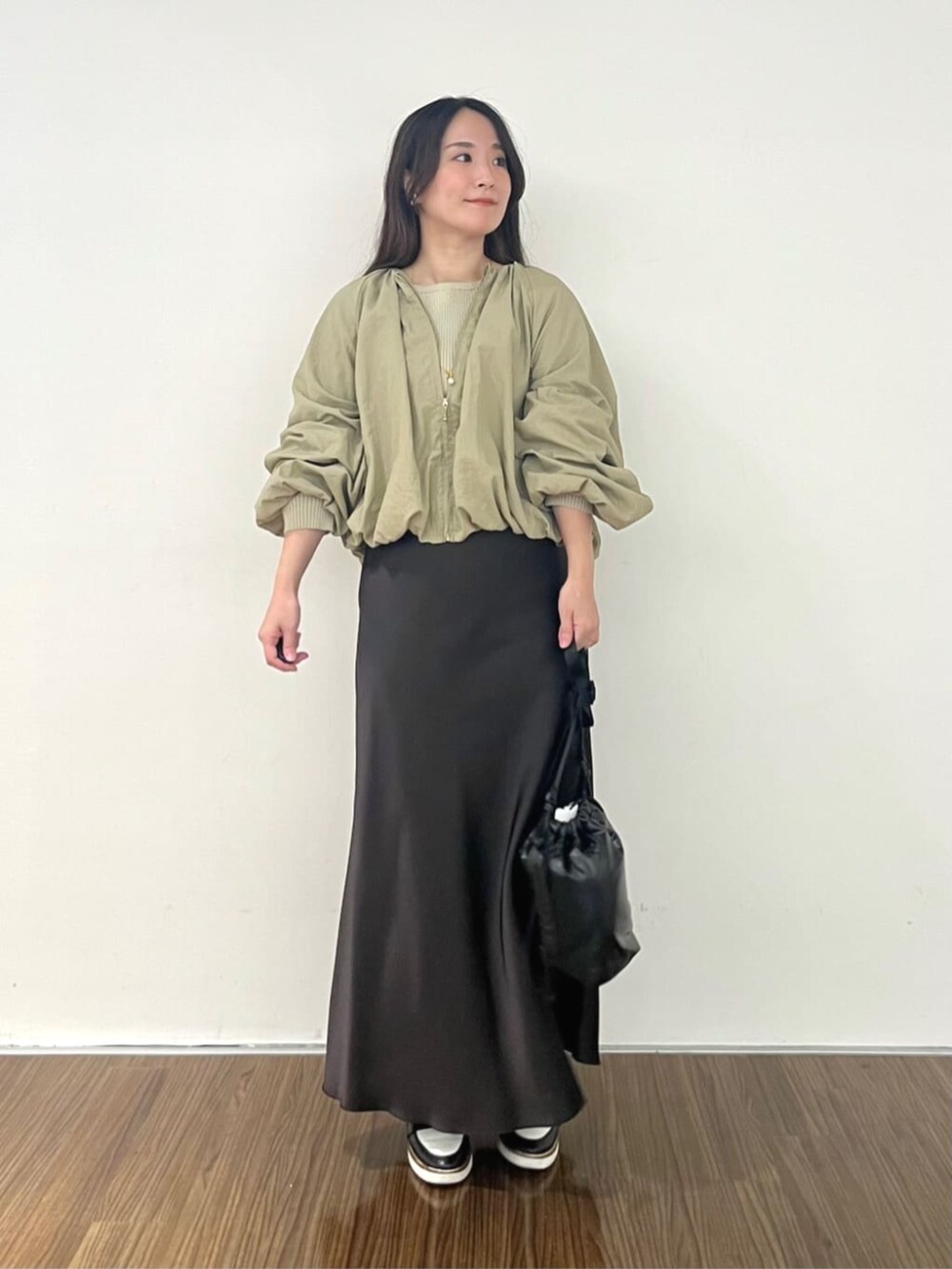 ブラウン系のブルゾン、グレー系のスカート、ベージュ系のニット/セーターを着用したレディースの秋コーディネートの2枚目の写真