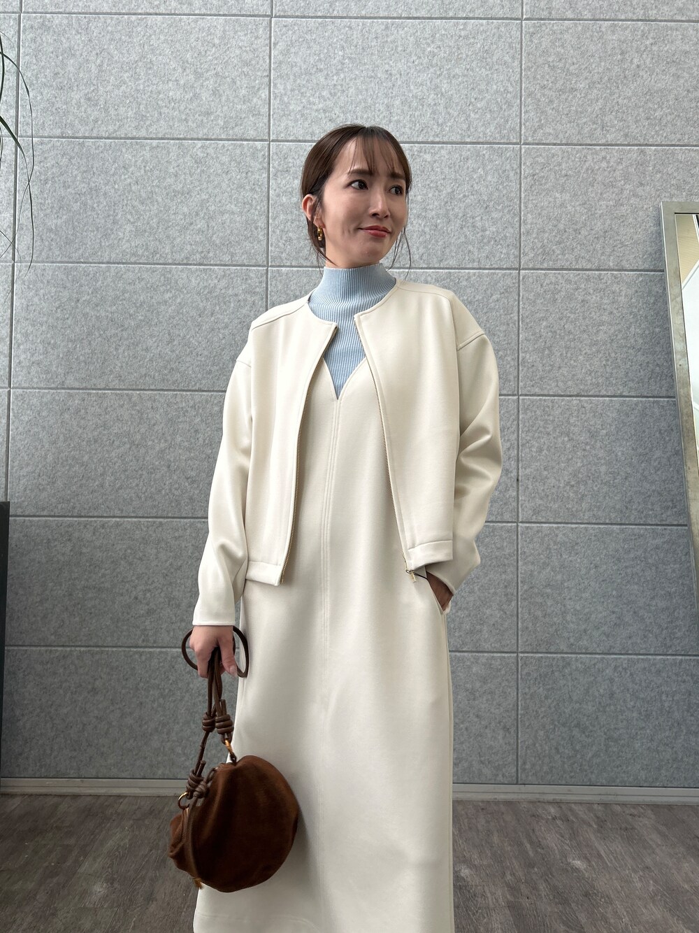 ブルー系のニット/セーター、ホワイト系のブルゾン、ホワイト系のワンピースを着用したレディースの秋コーディネートの6枚目の写真