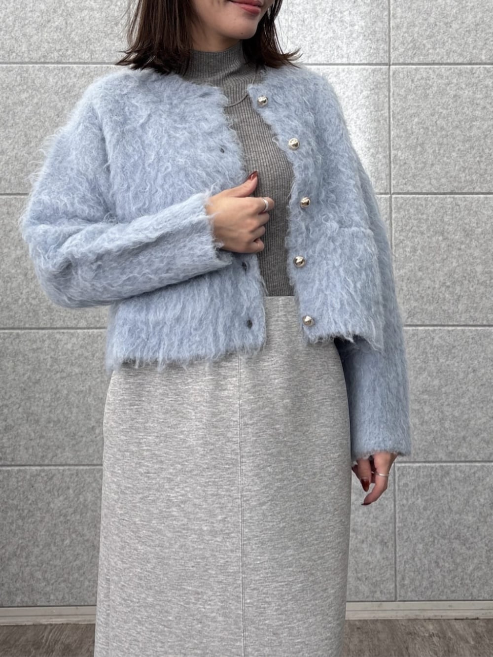グレー系のスカート、グレー系のニット/セーター、ブルー系のカーディガン/ボレロを着用したレディースの秋コーディネートの7枚目の写真