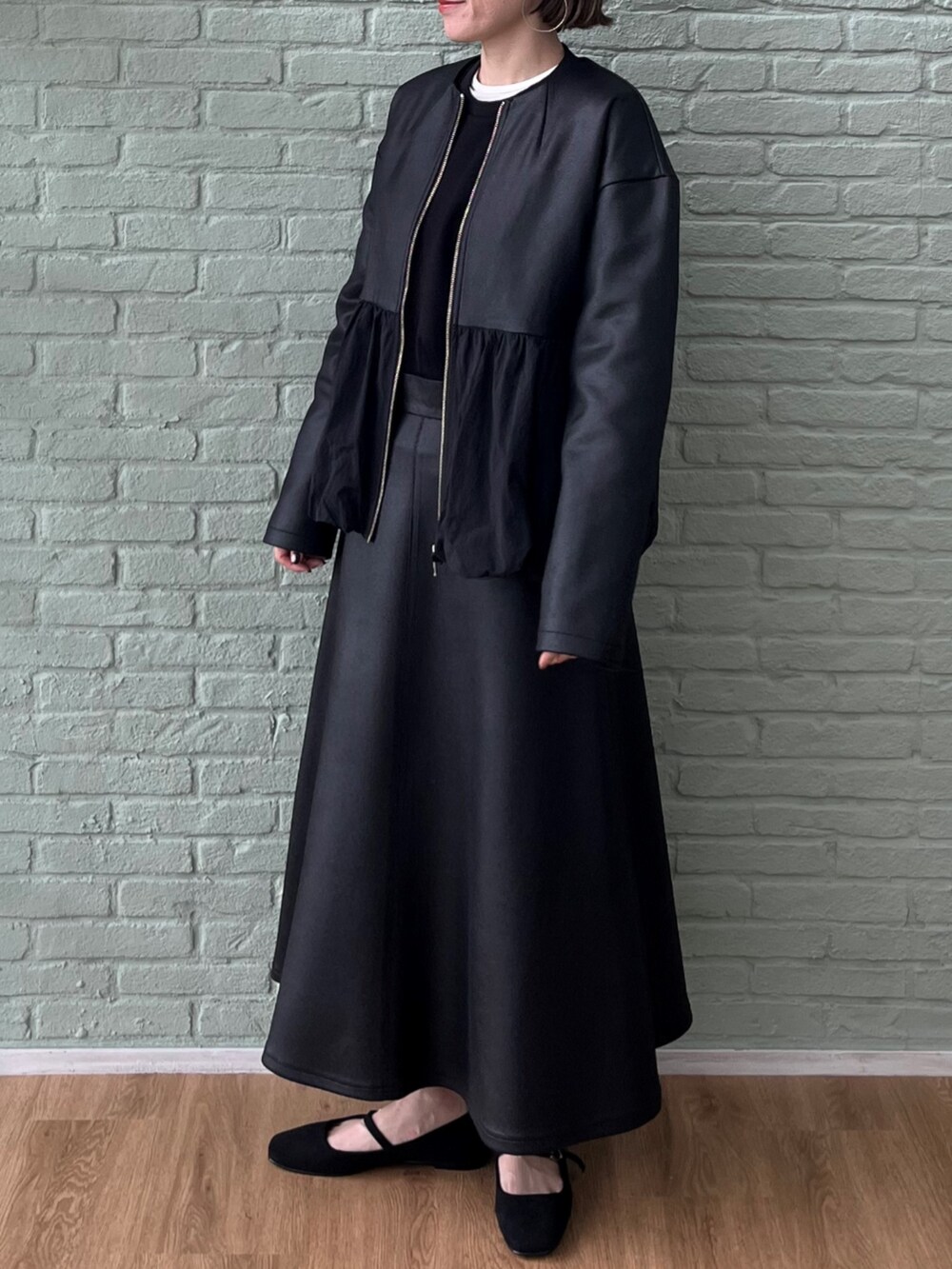 ブラック系のスカート、ブラック系のブルゾン、ブラック系のスウェットを着用したレディースの秋コーディネートの3枚目の写真