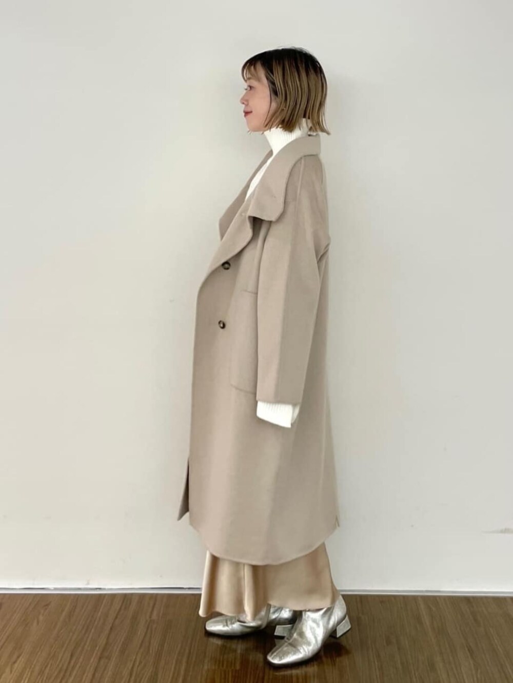 ベージュ系のスカート、ホワイト系のニット/セーター、ベージュ系のその他アウターを着用したレディースの秋コーディネートの3枚目の写真