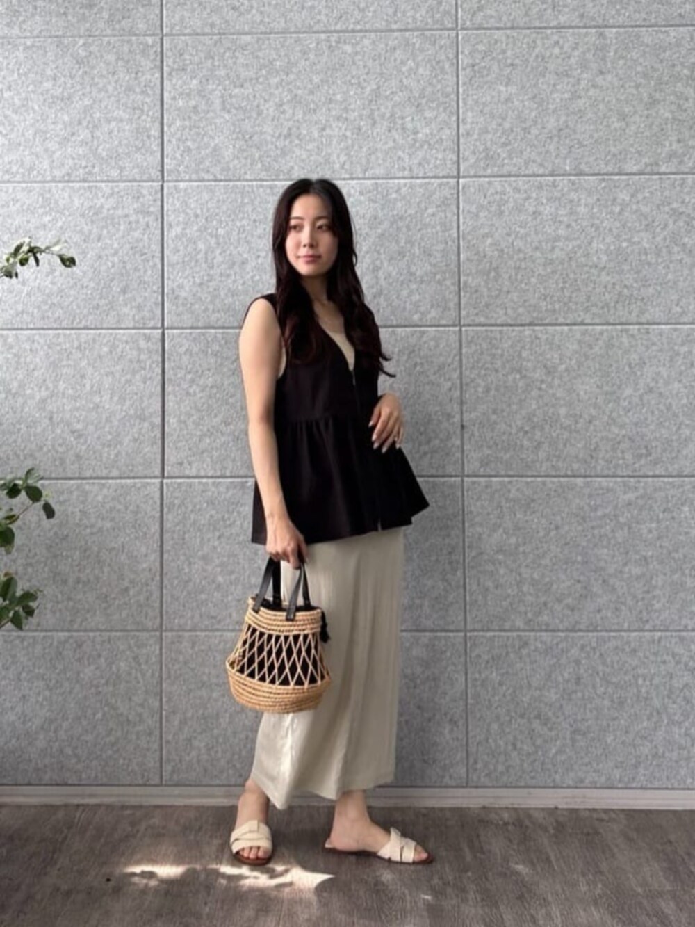 ベージュ系のタンクトップ、ベージュ系のスカート、ブラック系のシャツ/ブラウスを着用したレディースの夏コーディネートの3枚目の写真