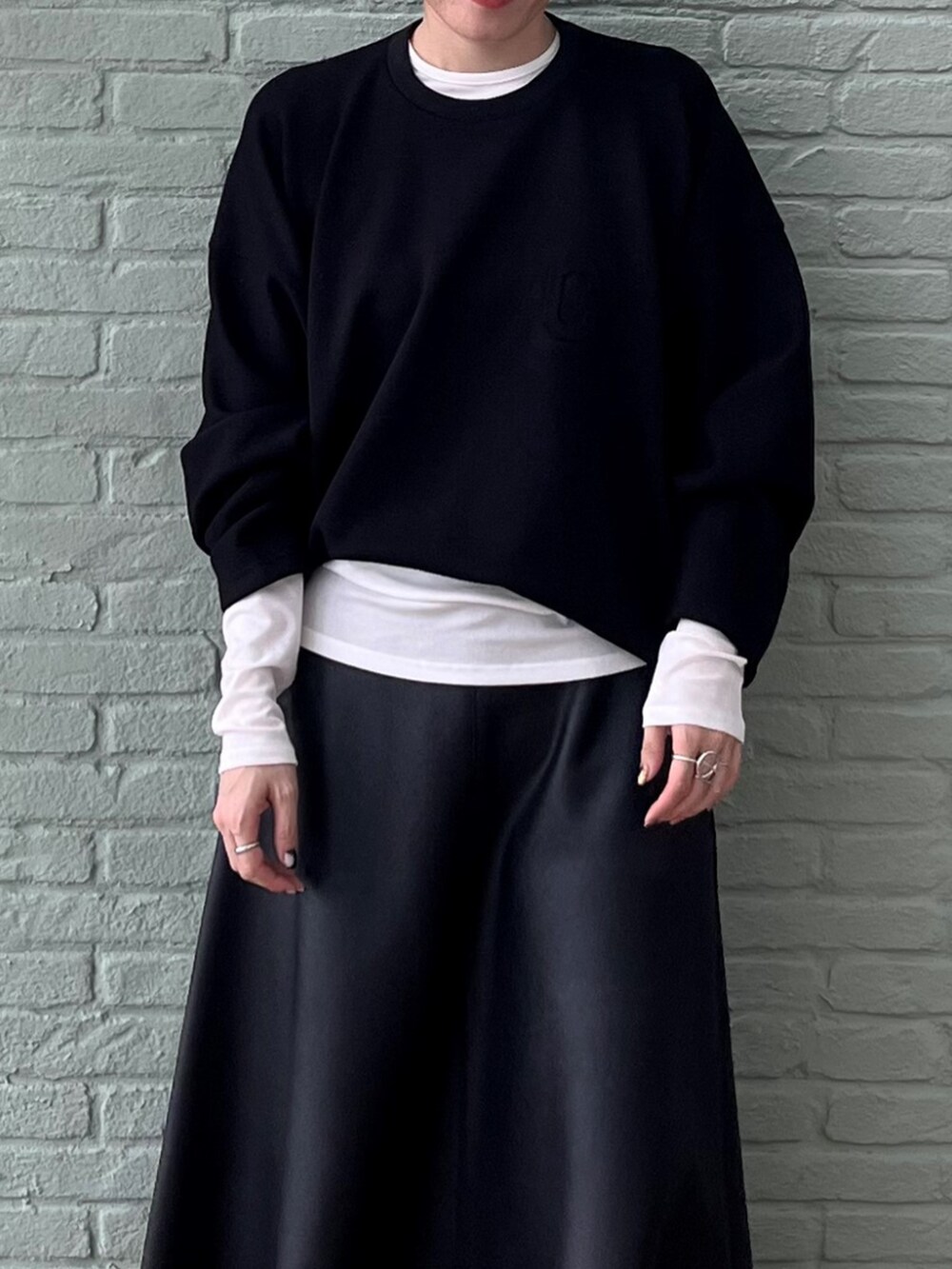 ホワイト系のTシャツ/カットソー、ブラック系のスカート、ブラック系のスウェットを着用したレディースの秋コーディネートの4枚目の写真