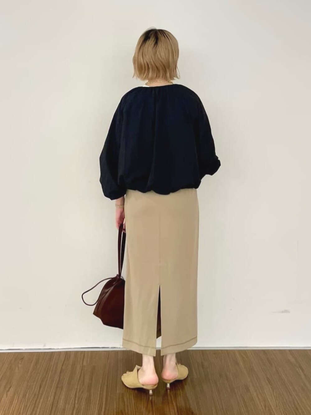 ブラック系のブルゾン、ブラウン系のスカート、ホワイト系のTシャツ/カットソーを着用したレディースの秋コーディネートの6枚目の写真