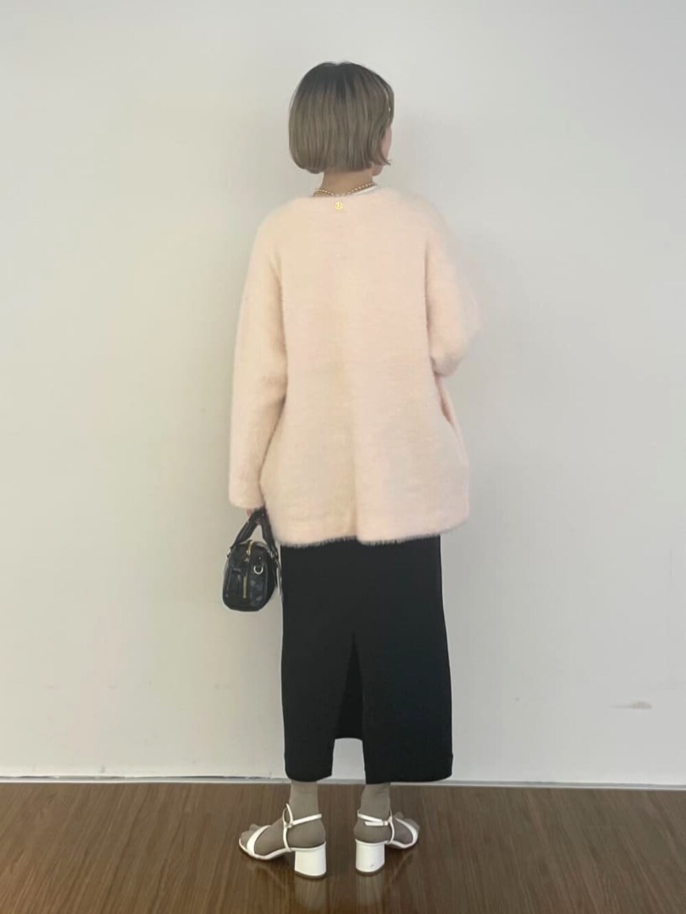 ピンク系のカーディガン/ボレロ、ブラック系のスカート、ホワイト系のTシャツ/カットソーを着用したレディースの秋コーディネートの4枚目の写真