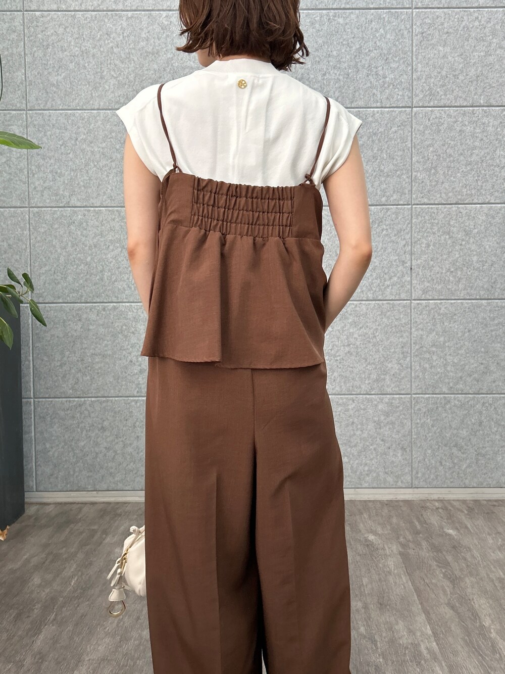 ホワイト系のニット/セーター、ブラウン系のサロペット/オーバーオールを着用したレディースの夏コーディネートの8枚目の写真