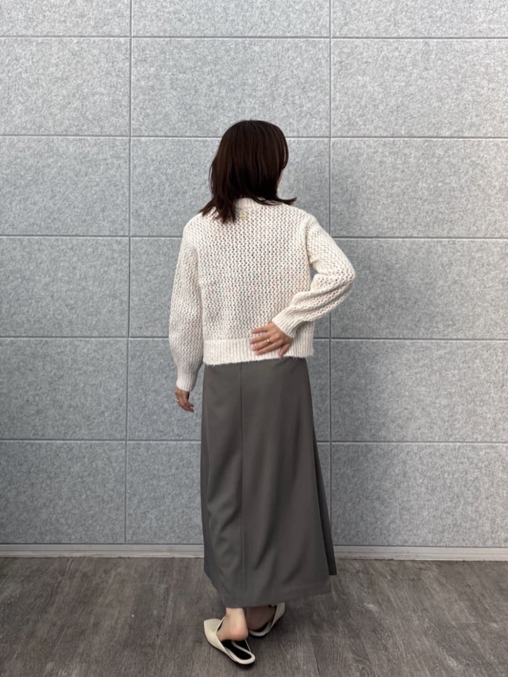 グレー系のスカート、ホワイト系のニット/セーターを着用したレディースの秋コーディネートの8枚目の写真