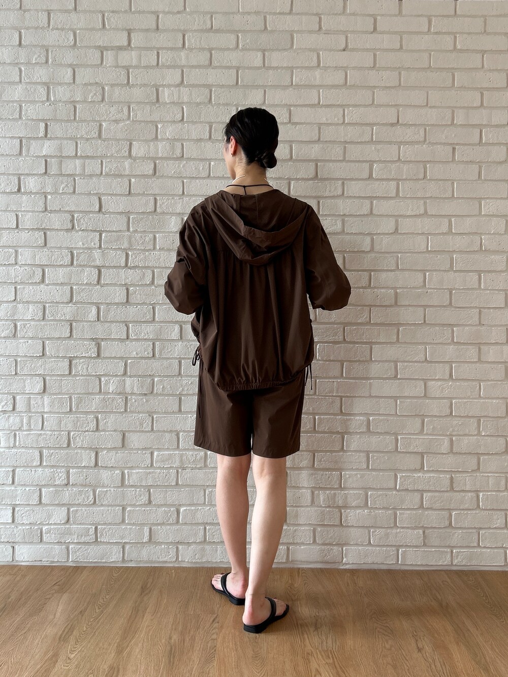 ブラウン系のブルゾン、ブラック系のタンクトップ、ブラウン系のその他パンツを着用したレディースの春コーディネートの5枚目の写真