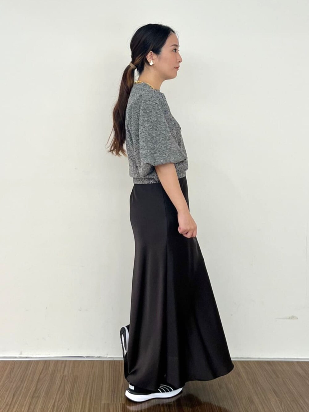 グレー系のスカート、ブラック系のニット/セーターを着用したレディースの秋コーディネートの3枚目の写真