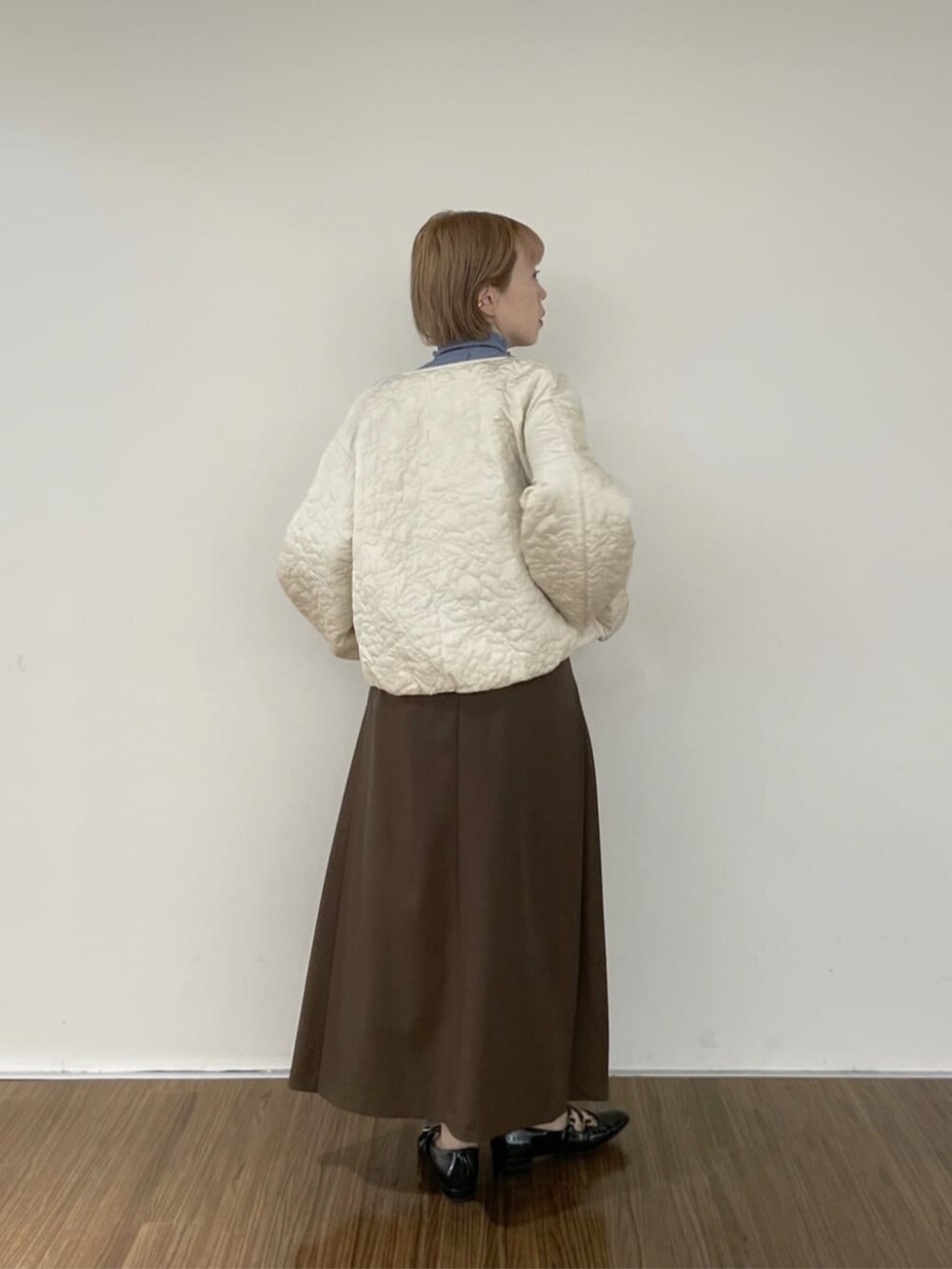 ブラウン系のスカート、ホワイト系のブルゾン、ブルー系のシャツ/ブラウスを着用したレディースの秋コーディネートの4枚目の写真
