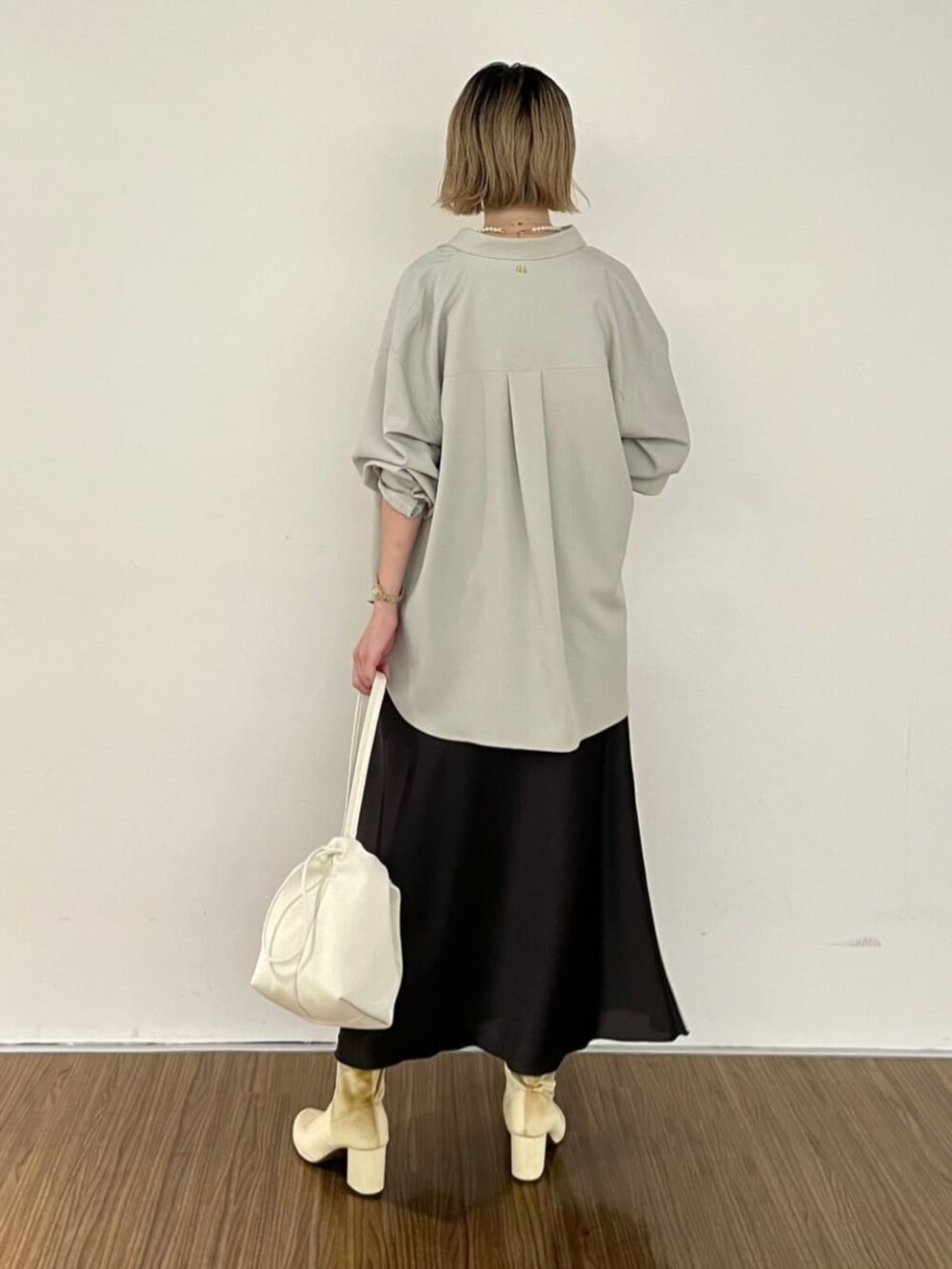 グレー系のスカート、ベージュ系のシャツ/ブラウスを着用したレディースの秋コーディネートの5枚目の写真