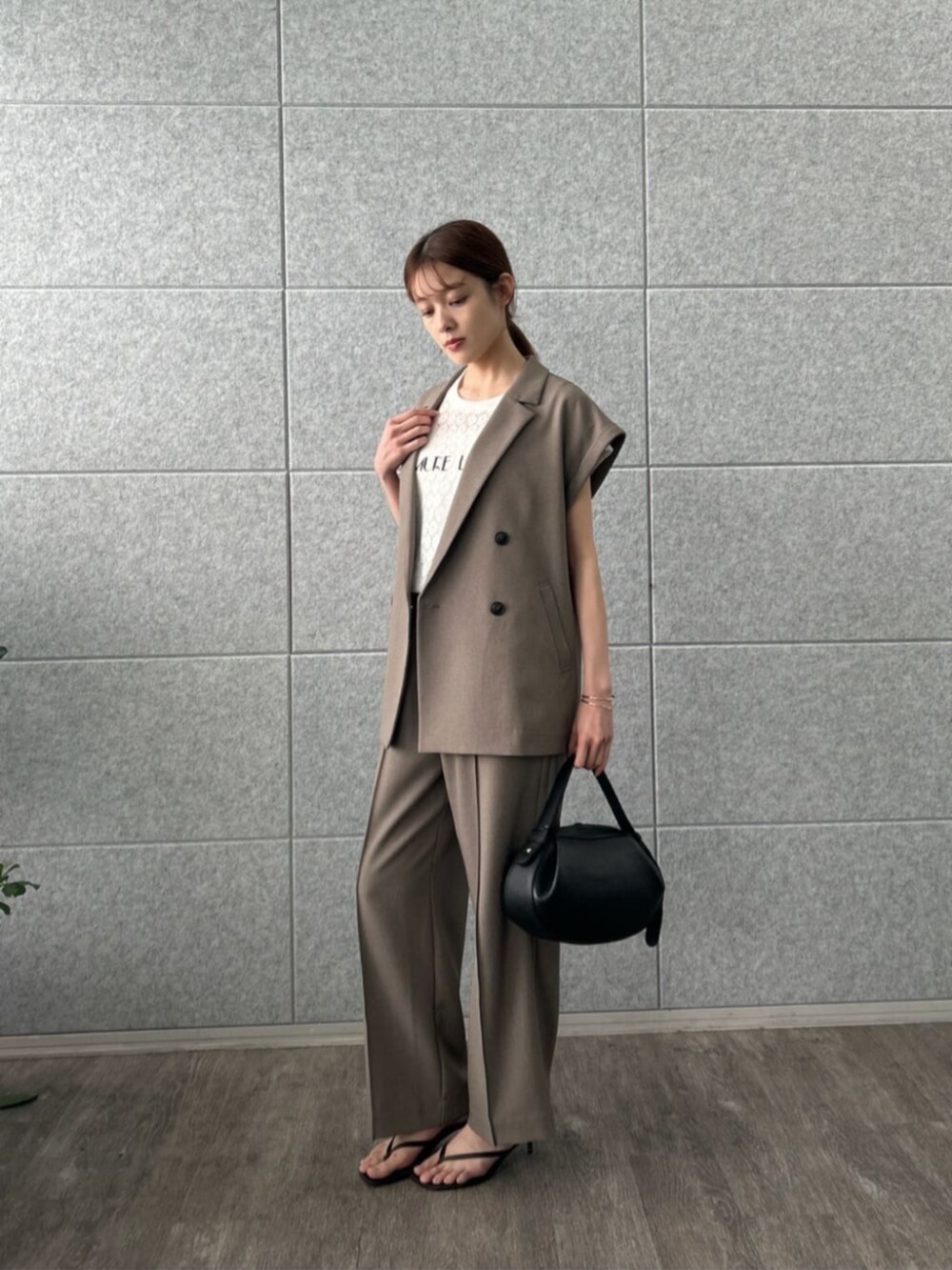 ブラウン系のテーラードジャケット、ブラウン系のその他パンツ、ホワイト系のTシャツ/カットソーを着用したレディースの夏コーディネートの2枚目の写真