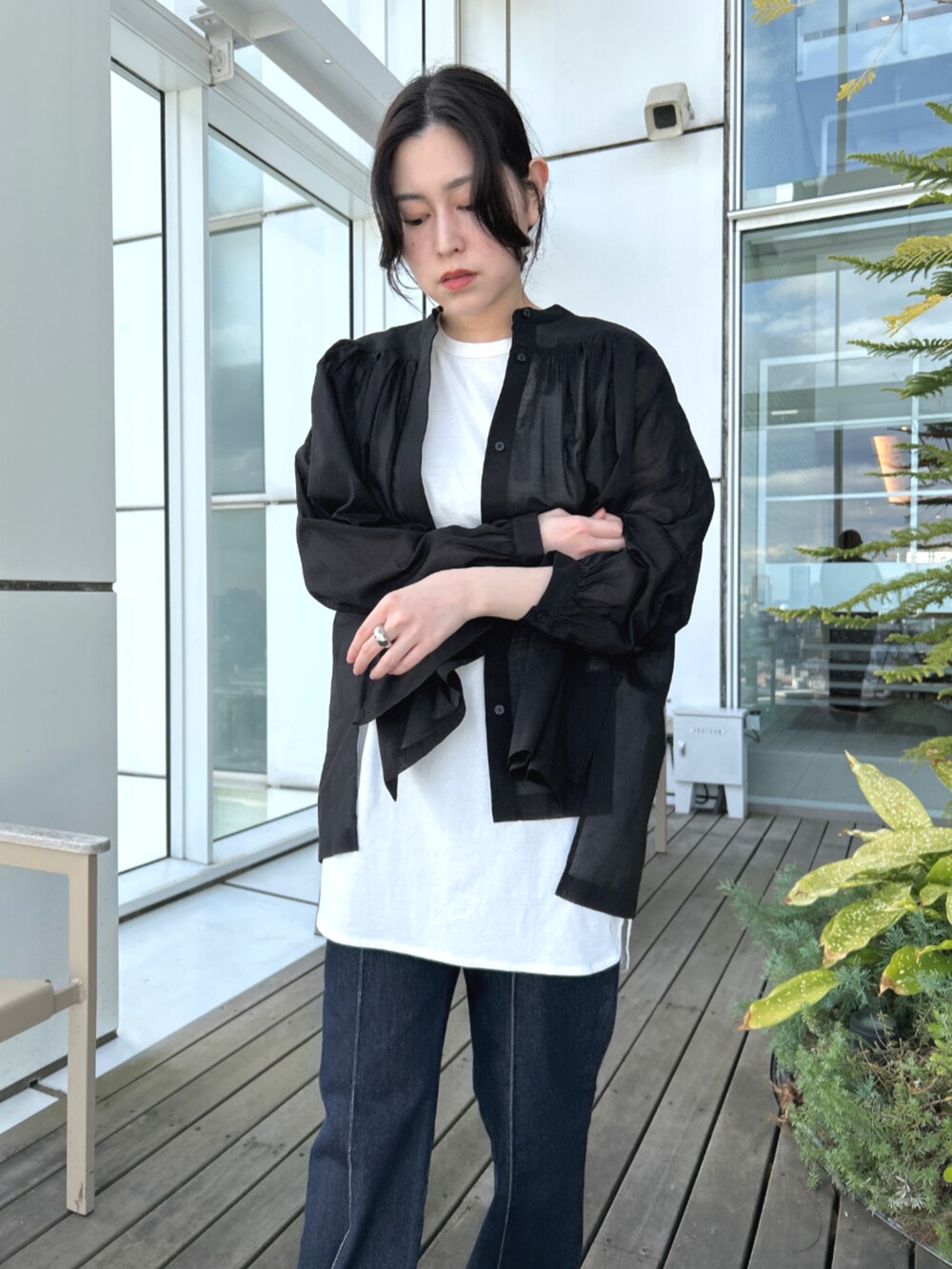 ブルー系のデニムパンツ、ホワイト系のTシャツ/カットソー、ブラック系のシャツ/ブラウスを着用したレディースの春コーディネートの6枚目の写真