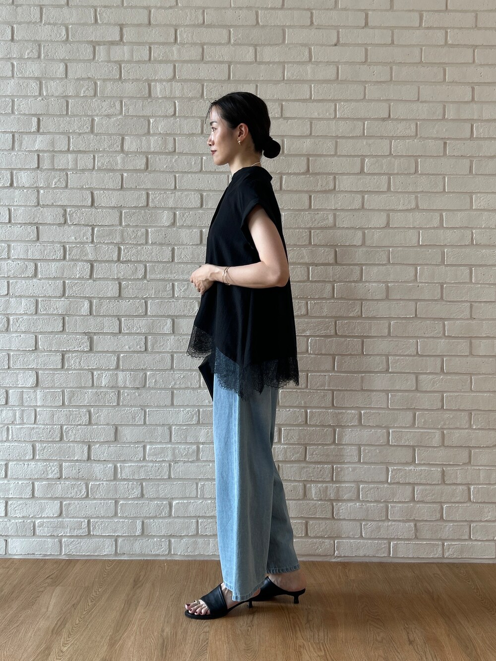 ブラック系のシャツ/ブラウス、ブルー系のデニムパンツを着用したレディースの春コーディネートの6枚目の写真