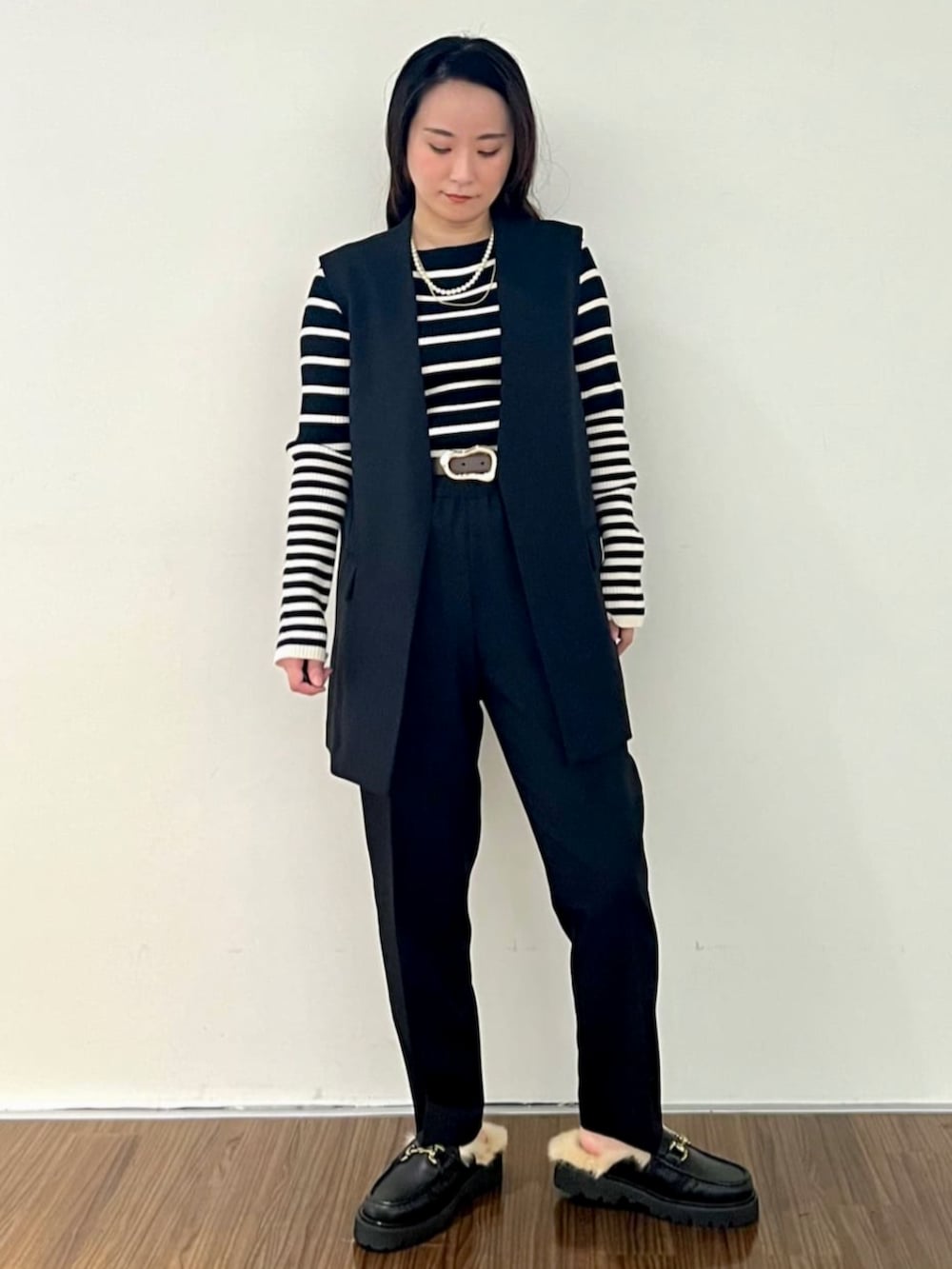 ブラック系のニット/セーター、ブラック系のその他パンツ、ブラック系のベストを着用したレディースの秋コーディネートの2枚目の写真