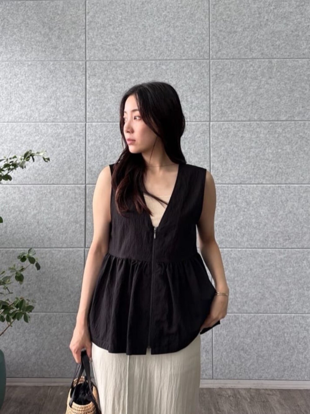 ベージュ系のタンクトップ、ベージュ系のスカート、ブラック系のシャツ/ブラウスを着用したレディースの夏コーディネートの5枚目の写真