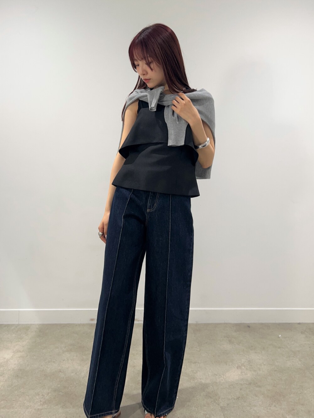 ブルー系のデニムパンツ、グレー系のカーディガン/ボレロ、ブラック系のシャツ/ブラウスを着用したレディースの春コーディネートの4枚目の写真