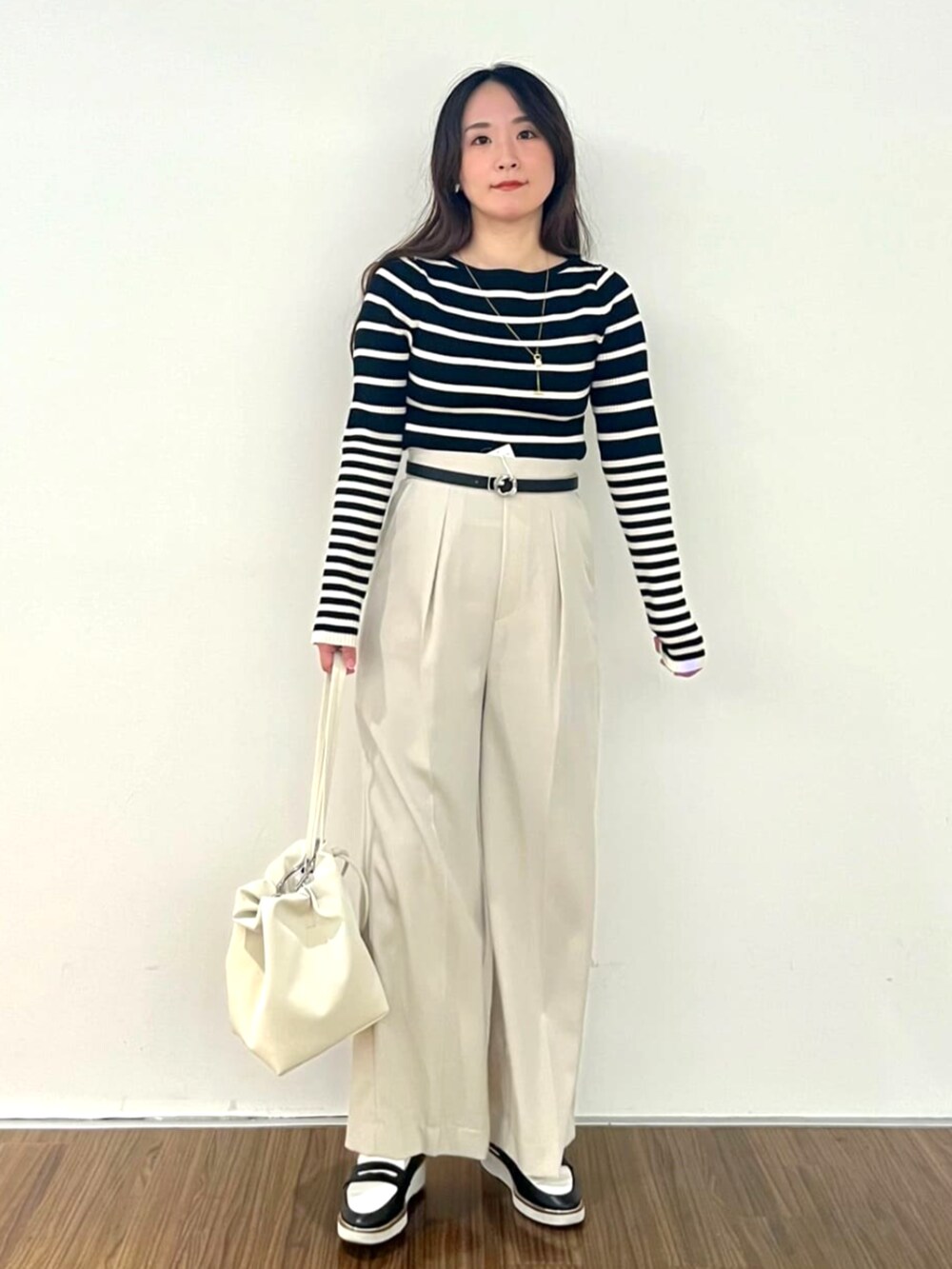 ブラック系のニット/セーター、ベージュ系のその他パンツを着用したレディースの秋コーディネートの2枚目の写真