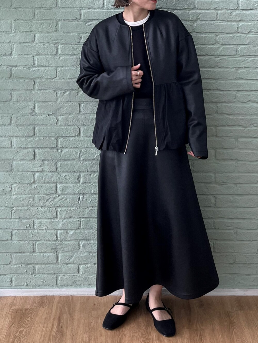 ブラック系のスカート、ブラック系のブルゾン、ブラック系のスウェットを着用したレディースの秋コーディネートの2枚目の写真