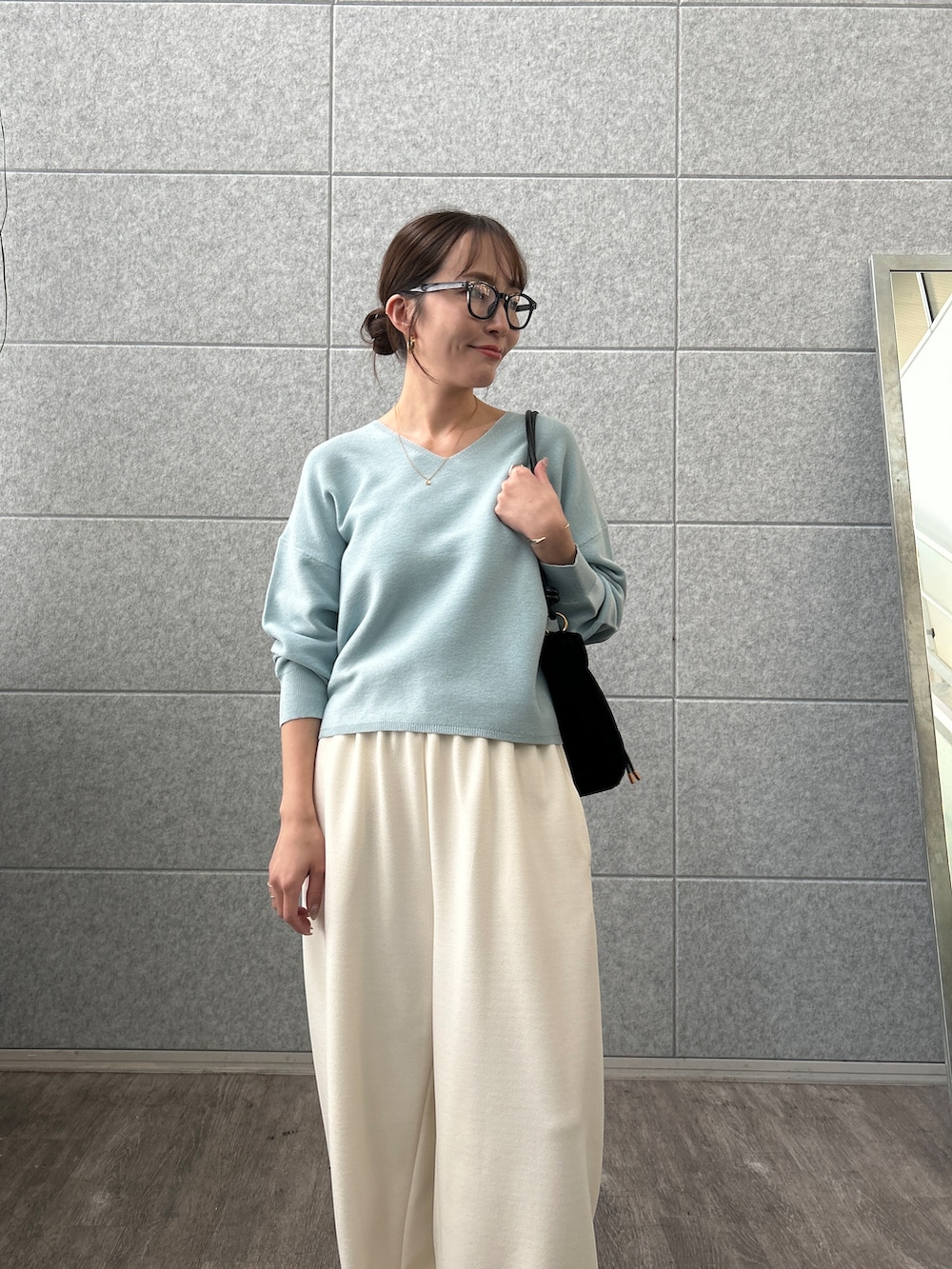 ブルー系のニット/セーター、ホワイト系のその他パンツを着用したレディースの秋コーディネートの8枚目の写真