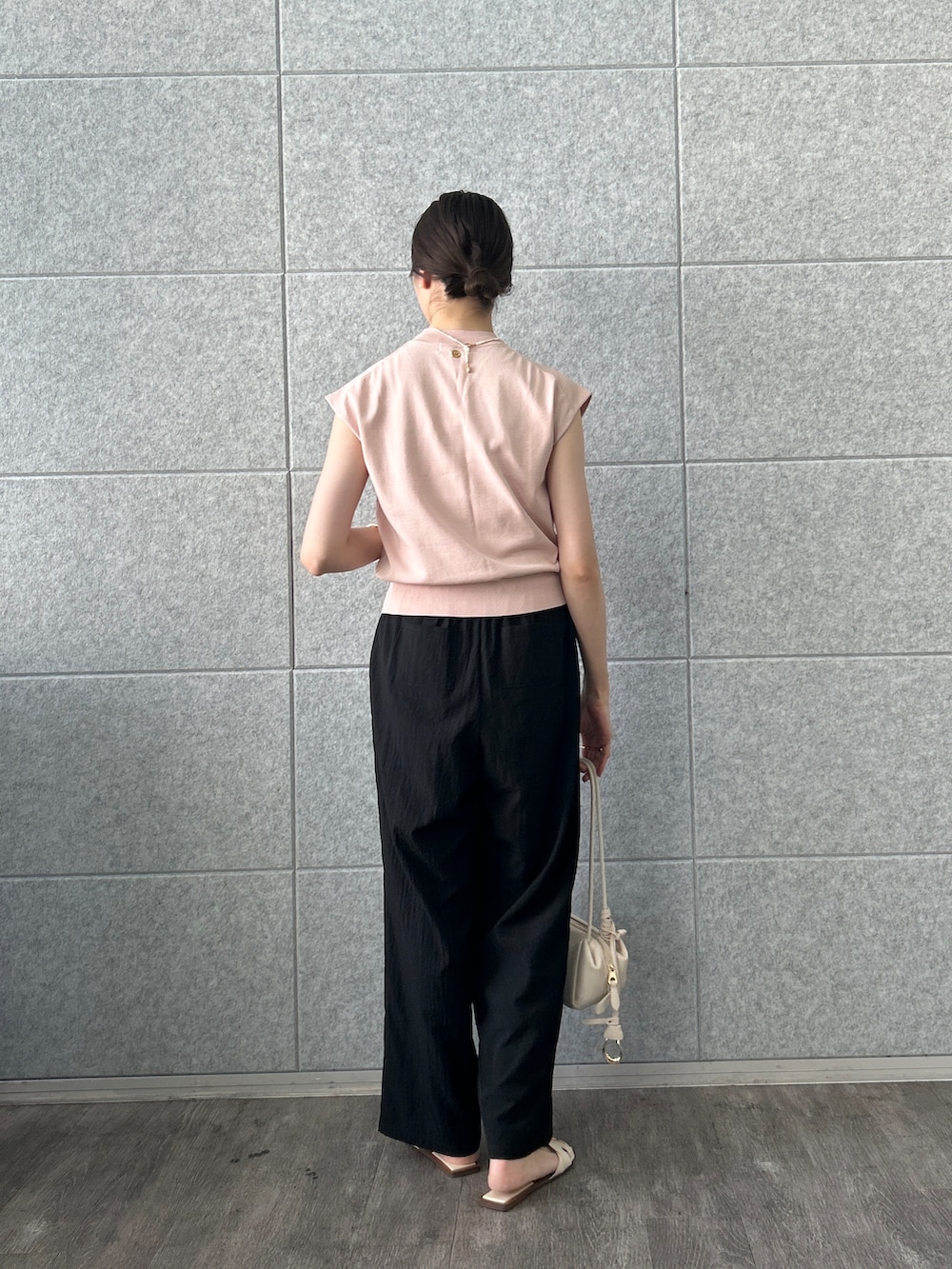 ピンク系のニット/セーター、ブラック系のその他パンツを着用したレディースの夏コーディネートの4枚目の写真