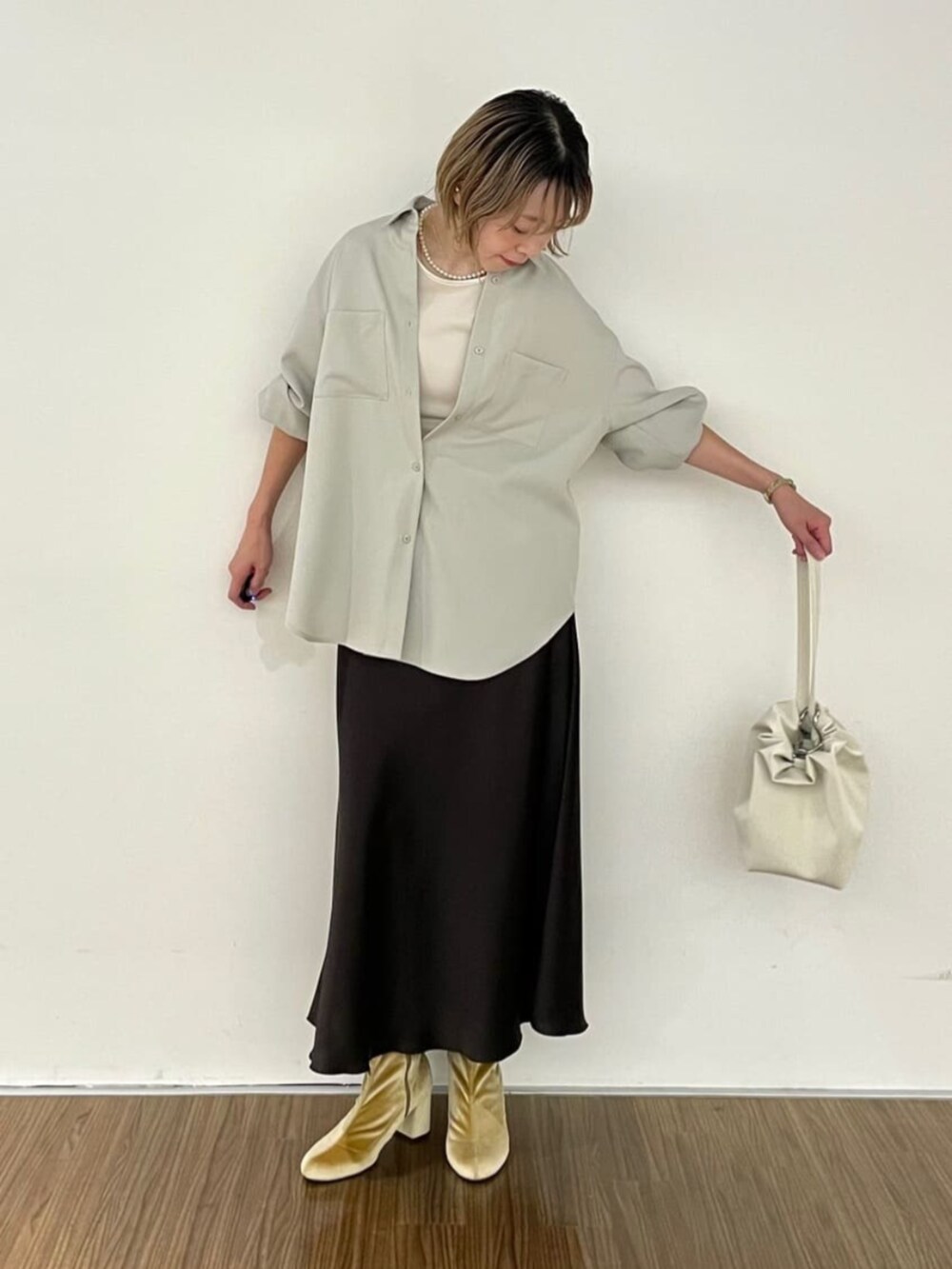 グレー系のスカート、ベージュ系のシャツ/ブラウスを着用したレディースの秋コーディネートの3枚目の写真