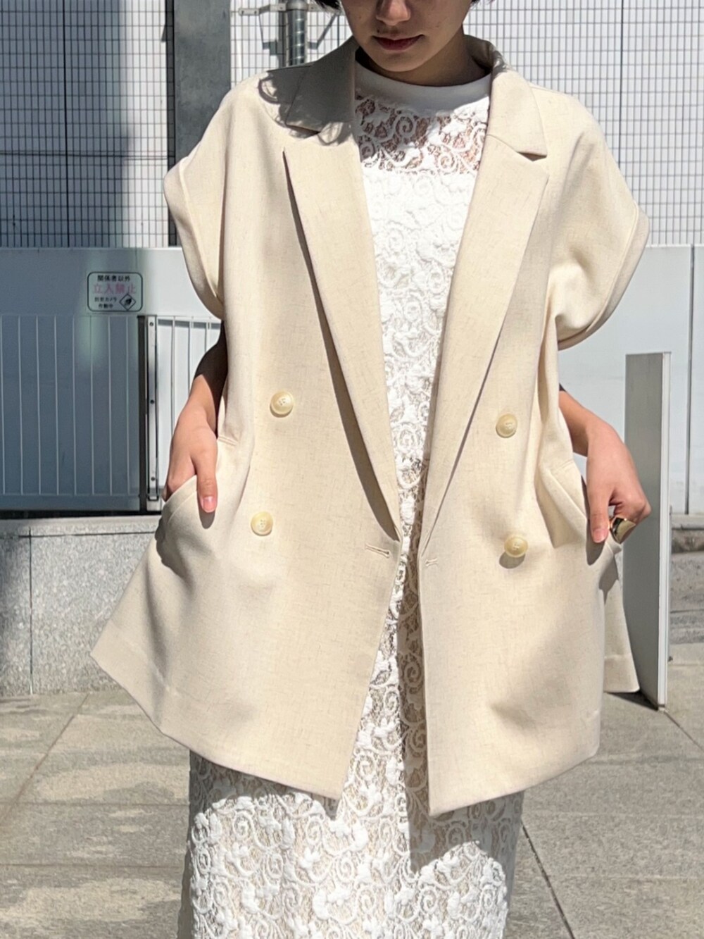 ホワイト系のタンクトップ、ホワイト系のテーラードジャケット、ホワイト系のワンピースを着用したレディースの春コーディネートの7枚目の写真