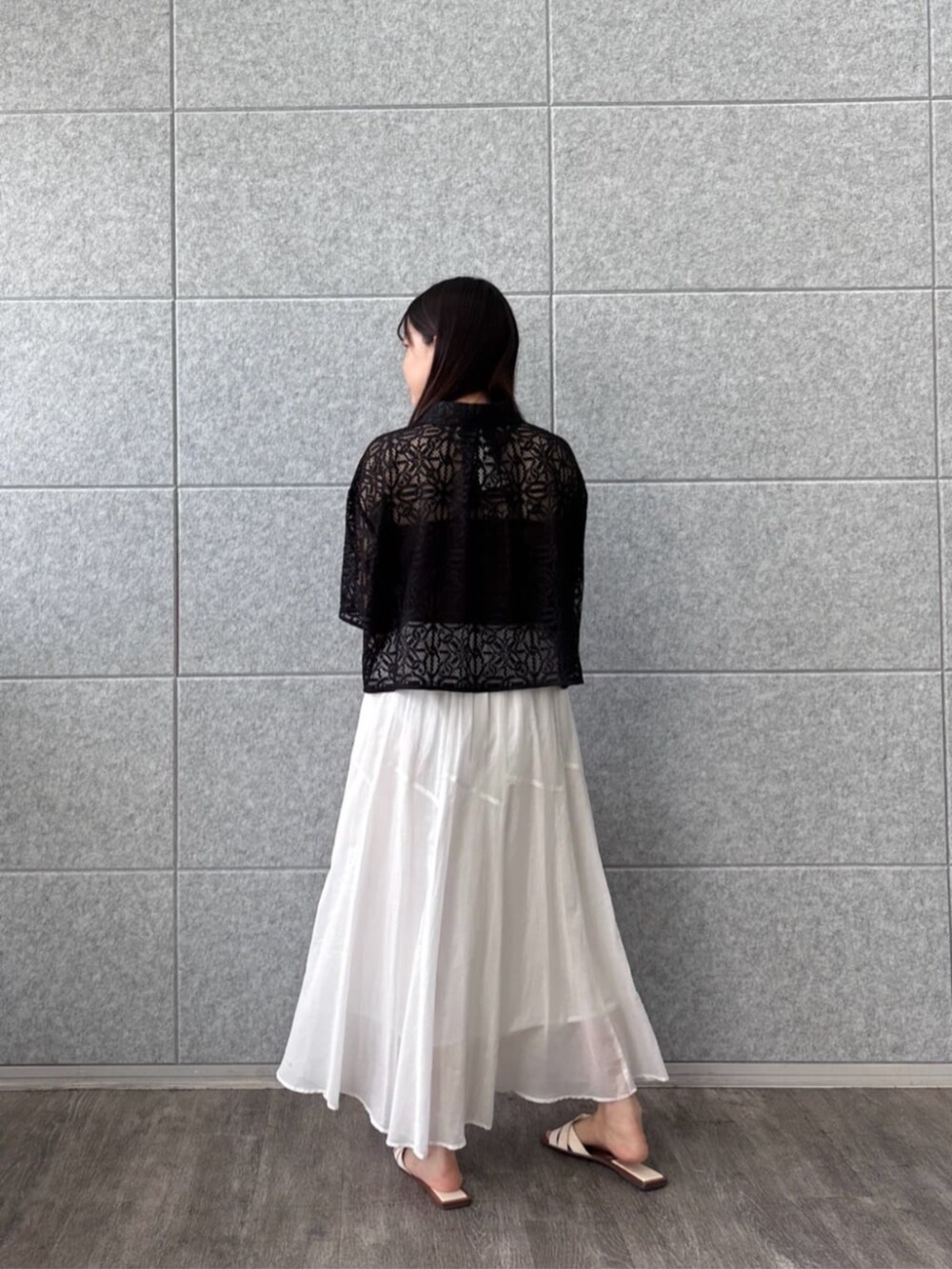 ホワイト系のスカート、ブラック系のシャツ/ブラウスを着用したレディースの夏コーディネートの2枚目の写真