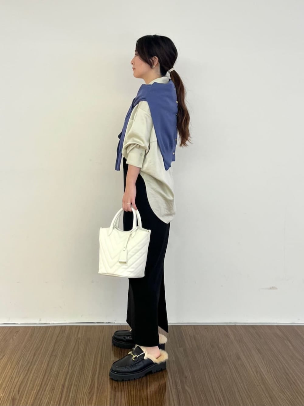 ブラック系のスカート、ベージュ系のシャツ/ブラウス、ブルー系のカーディガン/ボレロを着用したレディースの秋コーディネートの2枚目の写真