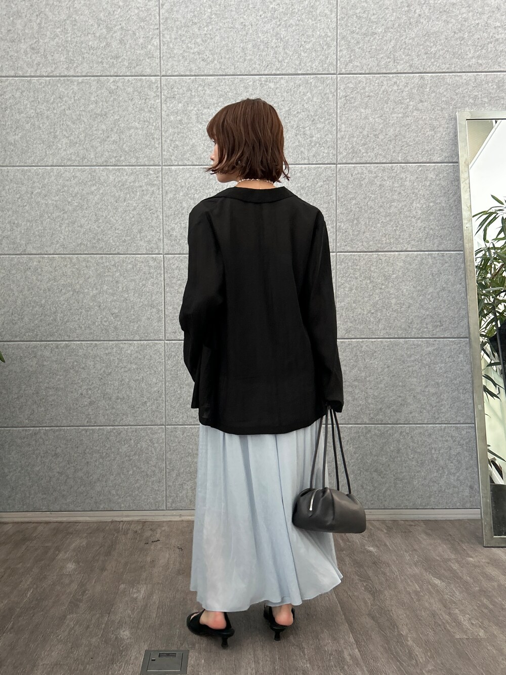 グレー系のタンクトップ、ブラック系のテーラードジャケット、ブルー系のその他パンツを着用したレディースの夏コーディネートの4枚目の写真