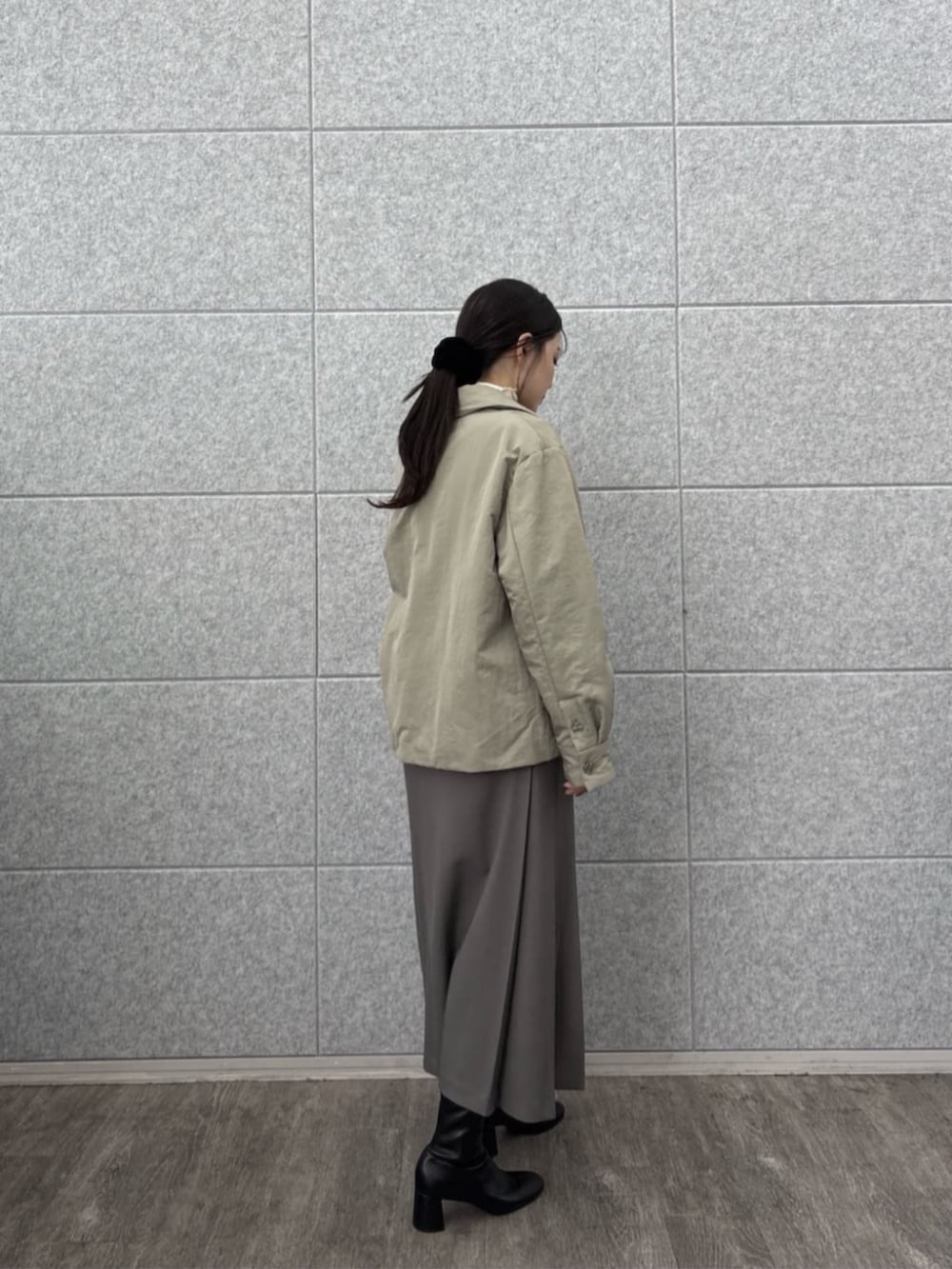 グレー系のスカート、ホワイト系のTシャツ/カットソー、グリーン系のブルゾンを着用したレディースの秋コーディネートの4枚目の写真