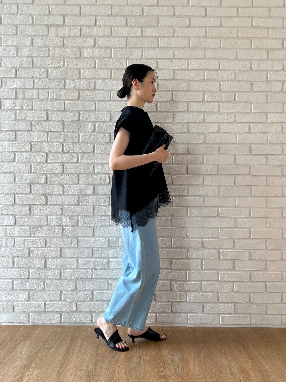 ブラック系のシャツ/ブラウス、ブルー系のデニムパンツを着用したレディースの春コーディネートの4枚目の写真