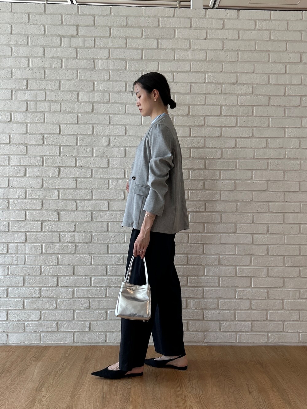 ブルー系のニット/セーター、グレー系のノーカラージャケット、ブラック系のその他パンツを着用したレディースの春コーディネートの5枚目の写真
