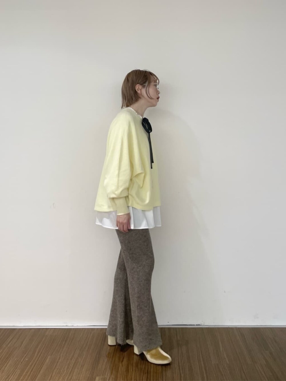 ホワイト系のシャツ/ブラウス、ブラウン系のその他パンツ、イエロー系のニット/セーターを着用したレディースの秋コーディネートの5枚目の写真