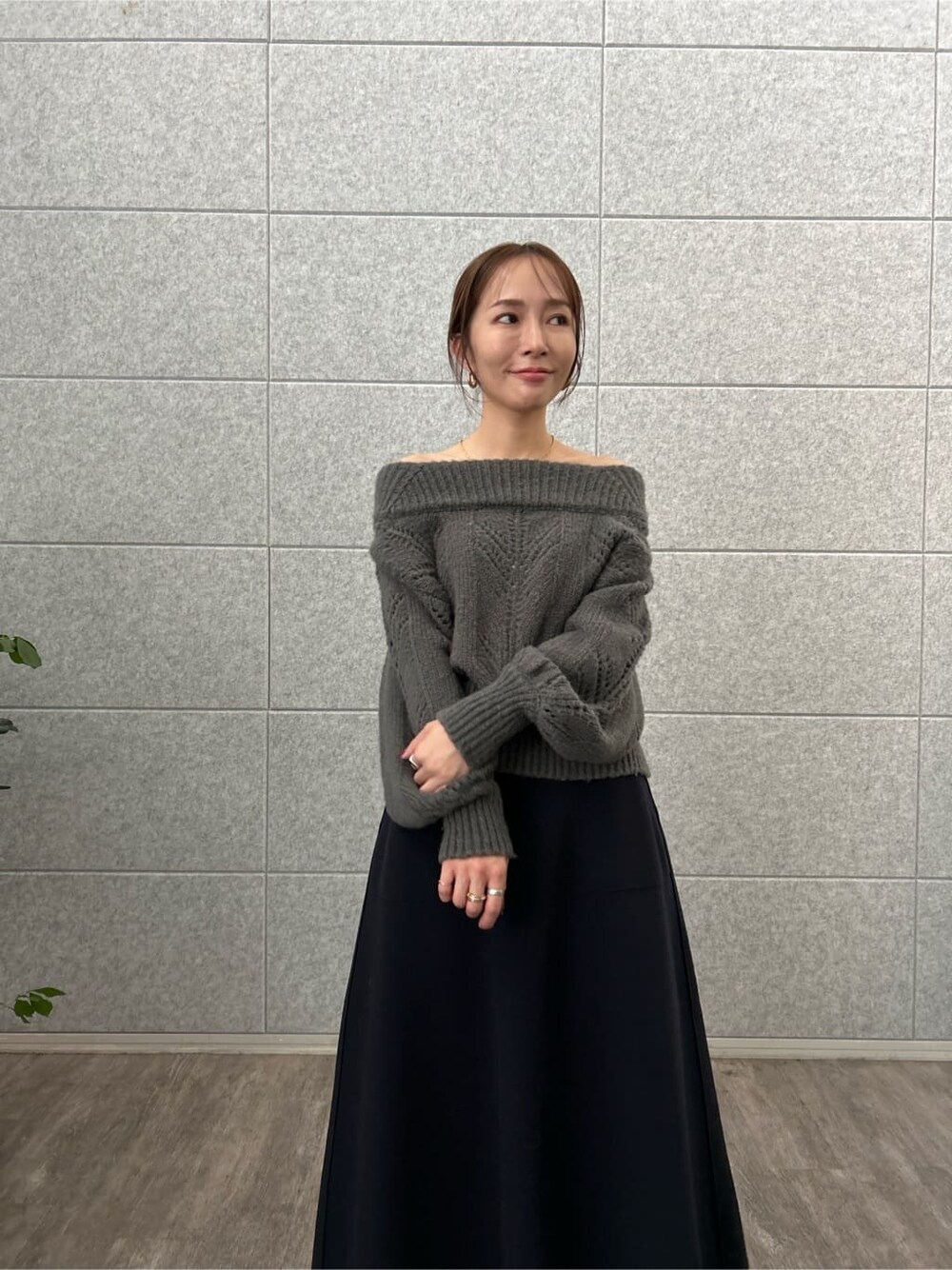 グレー系のニット/セーター、イエロー系のスカートを着用したレディースの秋コーディネートの6枚目の写真