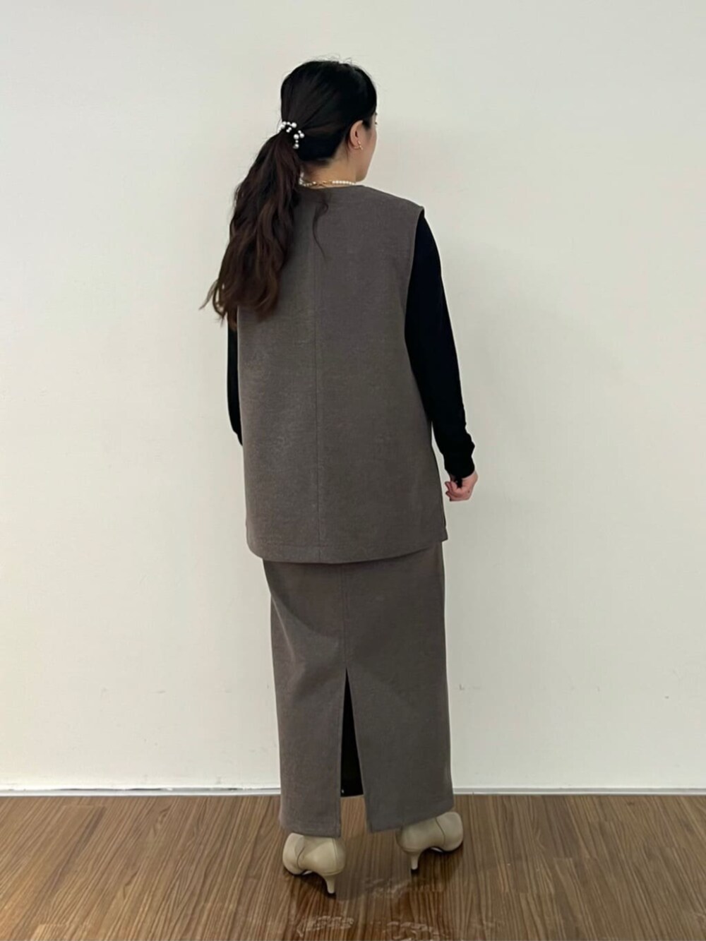 ブラウン系のベスト、ブラウン系のスカート、ブラック系のTシャツ/カットソーを着用したレディースの秋コーディネートの5枚目の写真