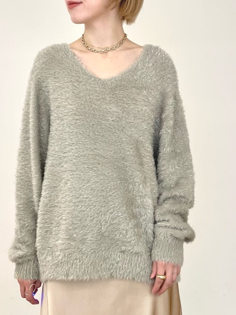 ベージュ系のスカート、グリーン系のニット/セーターを着用したレディースの冬コーディネートの3枚目の写真