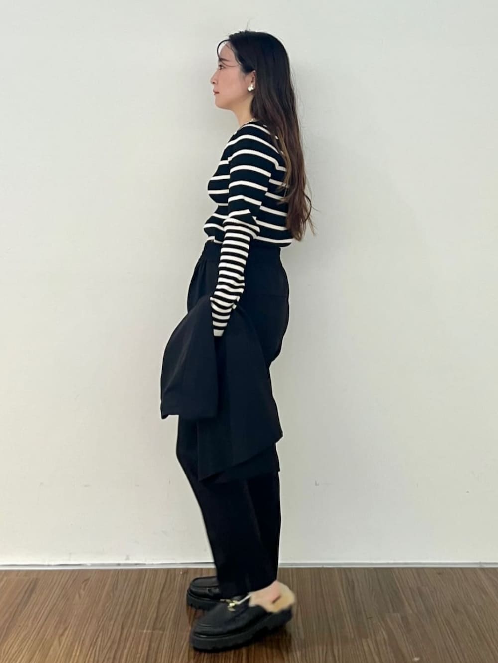 ブラック系のニット/セーター、ブラック系のその他パンツ、ブラック系のベストを着用したレディースの秋コーディネートの3枚目の写真