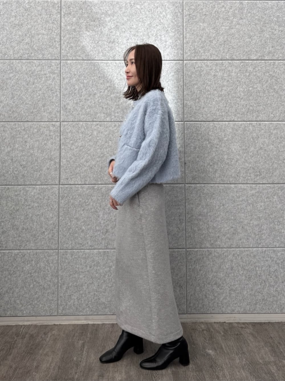 グレー系のスカート、グレー系のニット/セーター、ブルー系のカーディガン/ボレロを着用したレディースの秋コーディネートの6枚目の写真