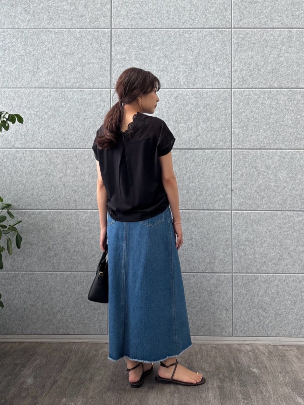 ブルー系のデニムスカート、ブラック系のTシャツ/カットソーを着用したレディースの夏コーディネートの3枚目の写真