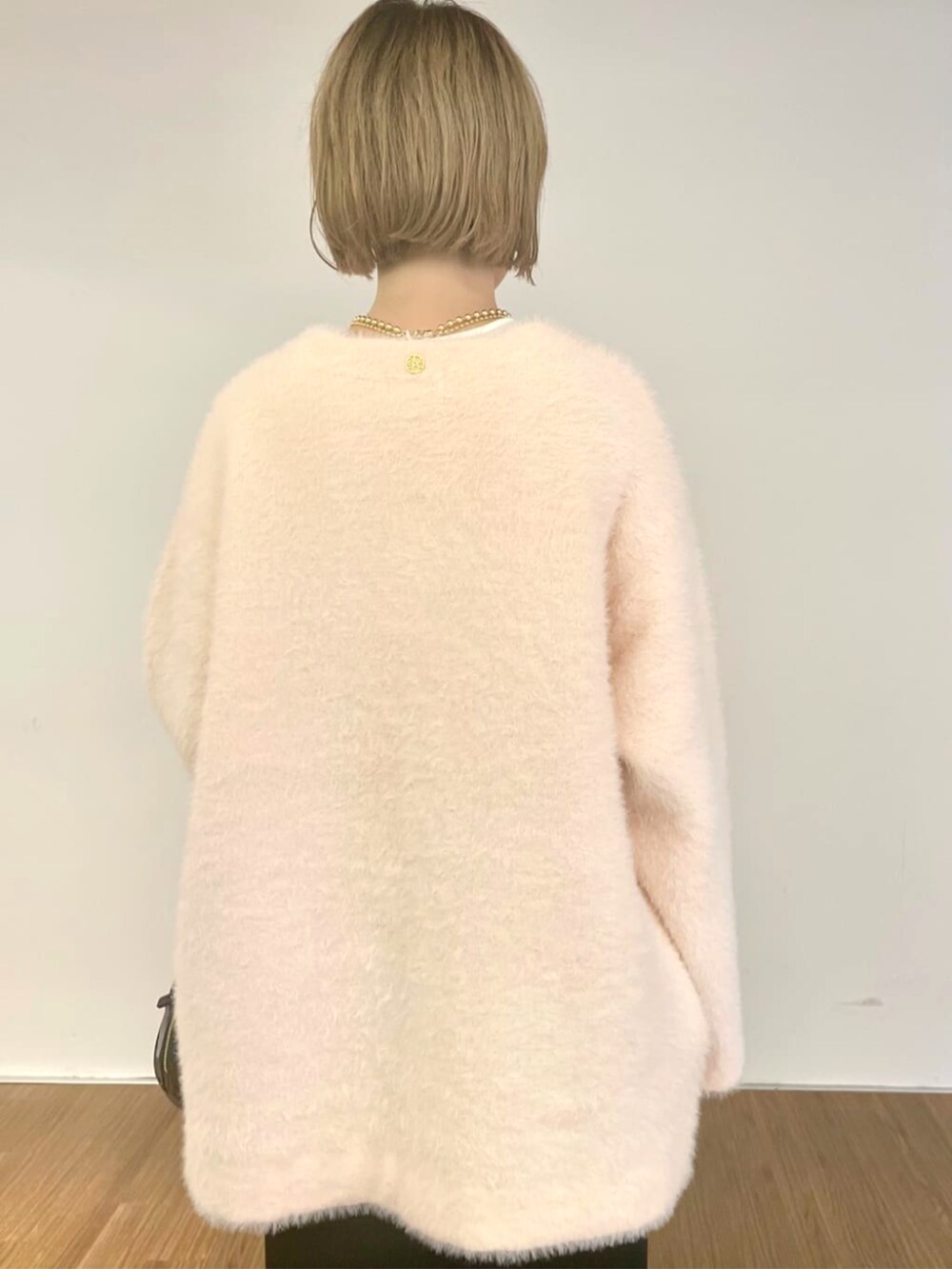 ピンク系のカーディガン/ボレロ、ブラック系のスカート、ホワイト系のTシャツ/カットソーを着用したレディースの秋コーディネートの7枚目の写真