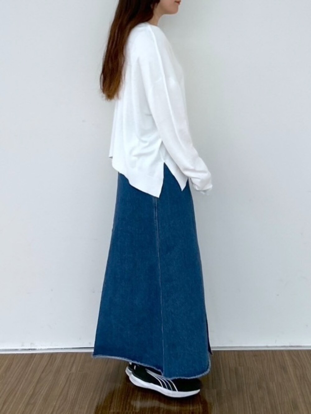 ブルー系のデニムスカート、ホワイト系のニット/セーターを着用したレディースの春コーディネートの4枚目の写真