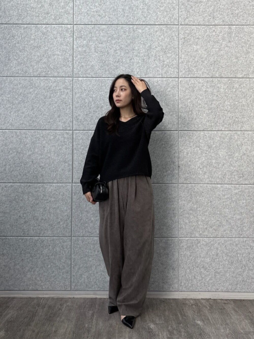 グレー系のその他パンツ、ブラック系のニット/セーターを着用したレディースの秋コーディネートの5枚目の写真