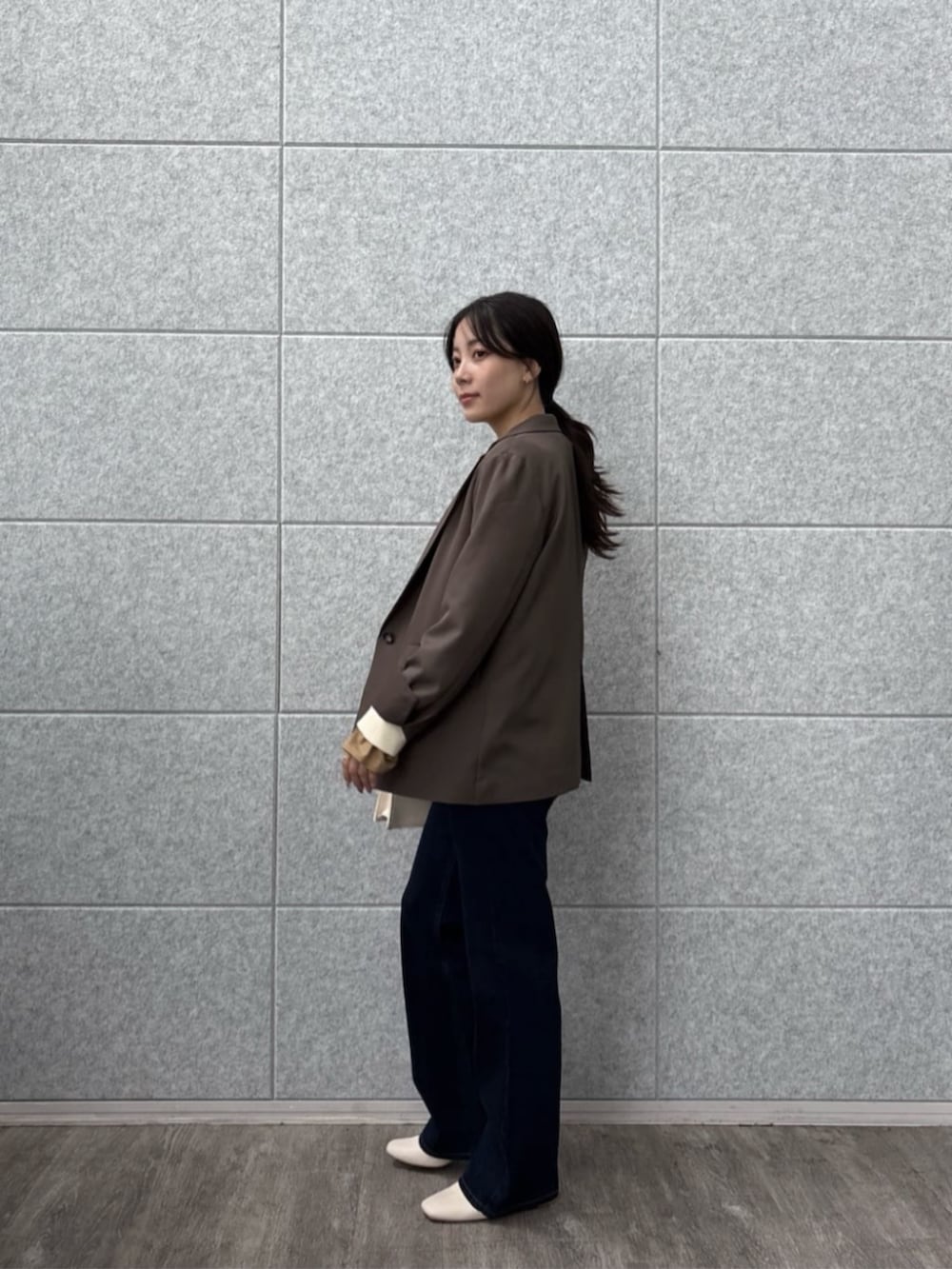 ブラウン系のテーラードジャケット、ブルー系のデニムパンツ、ホワイト系のニット/セーターを着用したレディースの秋コーディネートの4枚目の写真